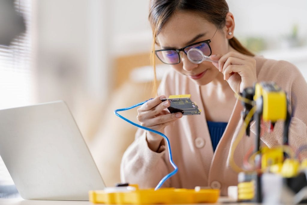 STEM Educated Asian Female Inspecting Electronics